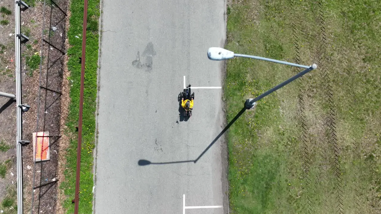 A top down view of a recumbent cyclist riding in a park on a sunny day