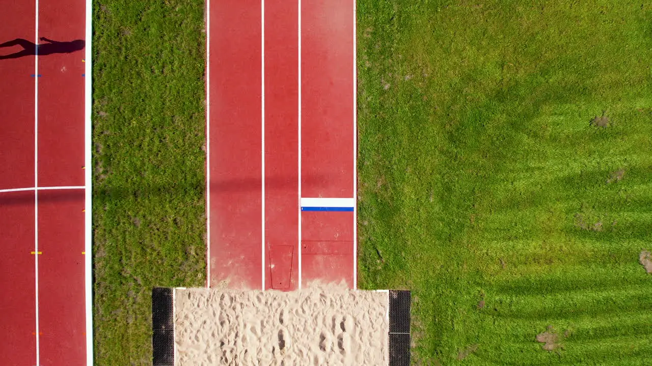 Aerial top down running track leading to the long jump sandpit at an athletics stadium