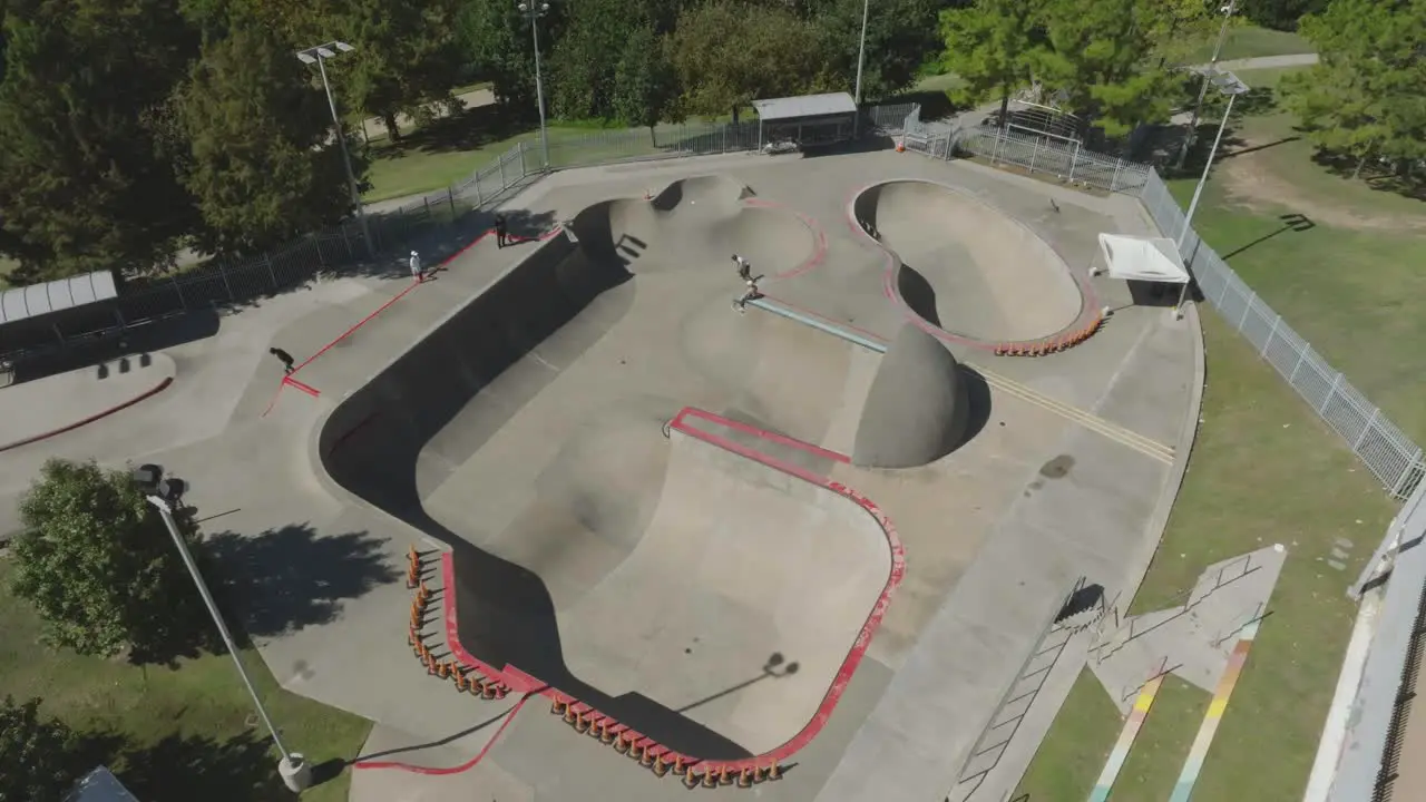 An ascending drone aerial view of skateboarders at Lee and Joe Jamail Skatepark in Buffalo Bayou Park in Houston Texas