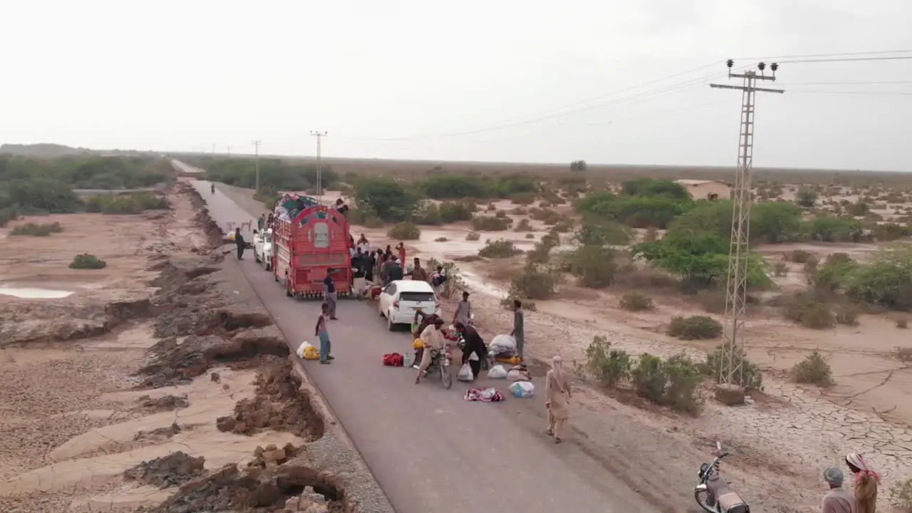 Aerial View Of Locals Strapping Food Supplies To Motorbike In Remote Area In Balochistan