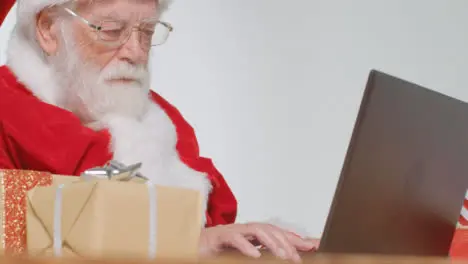 Low Angle Shot of Santa Typing On Laptop