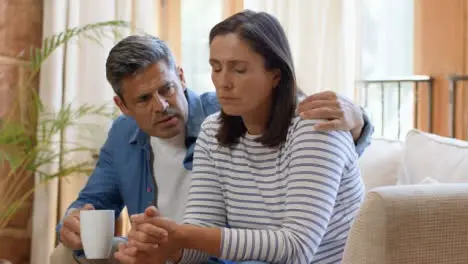 Wide Shot of Man Attempting to Comfort Visibly Concerned Wife