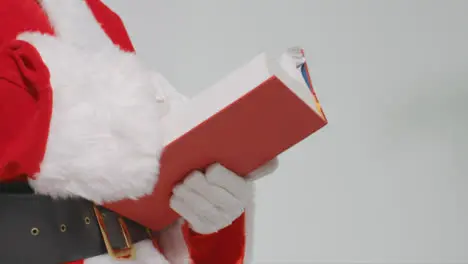 Close Up Shot of Santas Hands Holding Big Red Book