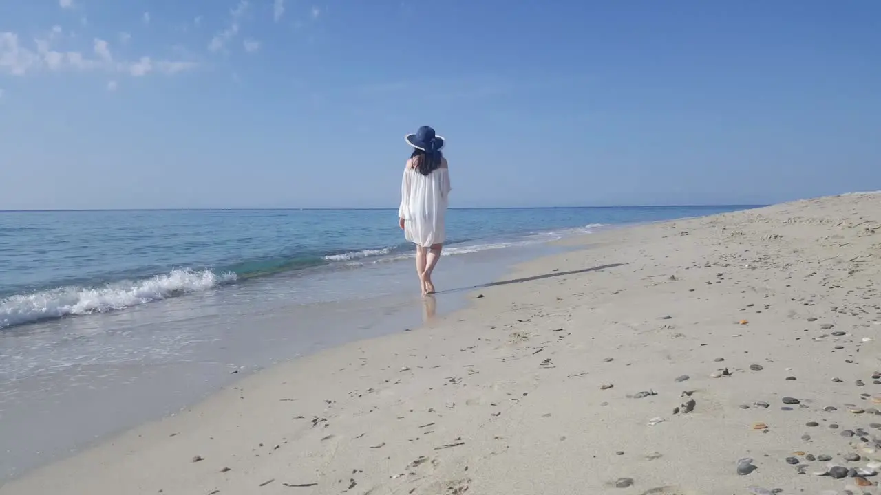 Beautiful women walking on the sandy beach in Greece