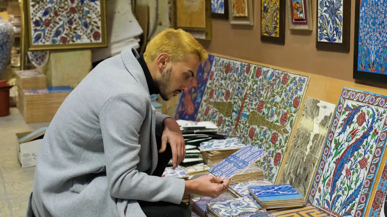 High Angle Shot of Man Looking at Tiles