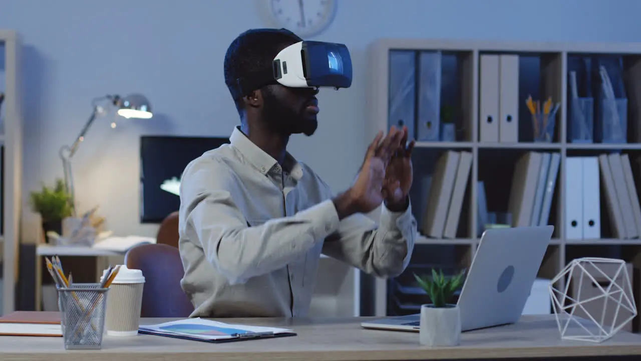 Young Office Worker Wearing A Vr Headset Scrolling And Taping In The Air In The Office At Night