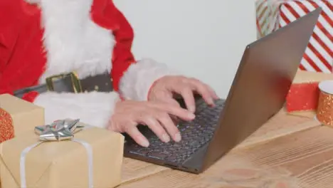 High Angle Shot of Santa Typing On Laptop