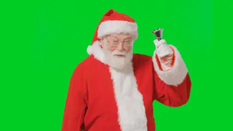 Portrait Shot of Santa Ringing a Bell In Front of a Green Screen