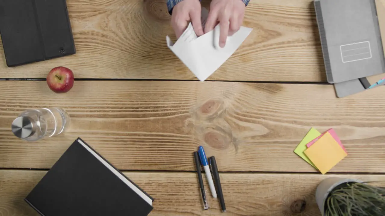 Overhead Shot of Man Opening Envelope