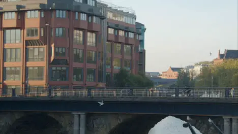 Wide Shot of People and Cyclists Travelling Over Bristol Bridge In Bristol England