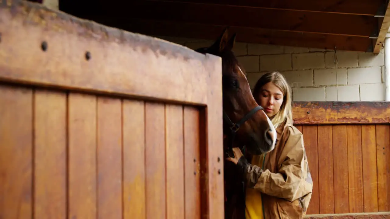 Woman standing with horse in stable 4k