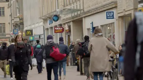 Long Shot of Crowd of People Walking Down Busy Street In Oxford England