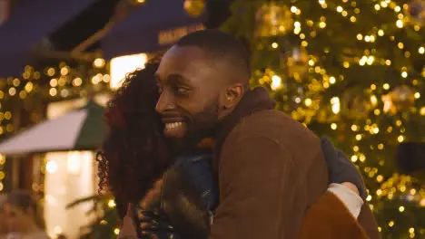 Loving Couple Hugging Walking Along Street On Christmas Shopping Trip To London 1