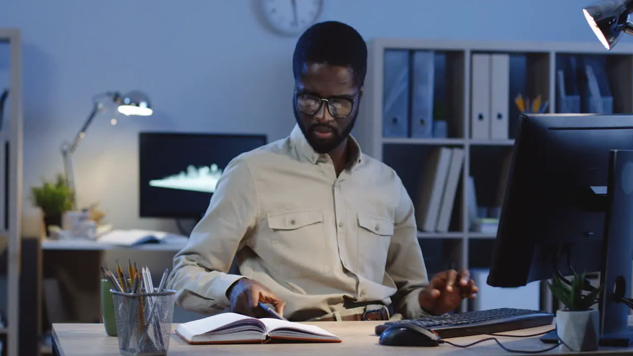 Young Man Working On The Computer When Getting A Message On His Smartphone And It Cheering Him Up 1