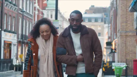 Couple Walking Arm In Arm Through Street On Winter Visit To London 1