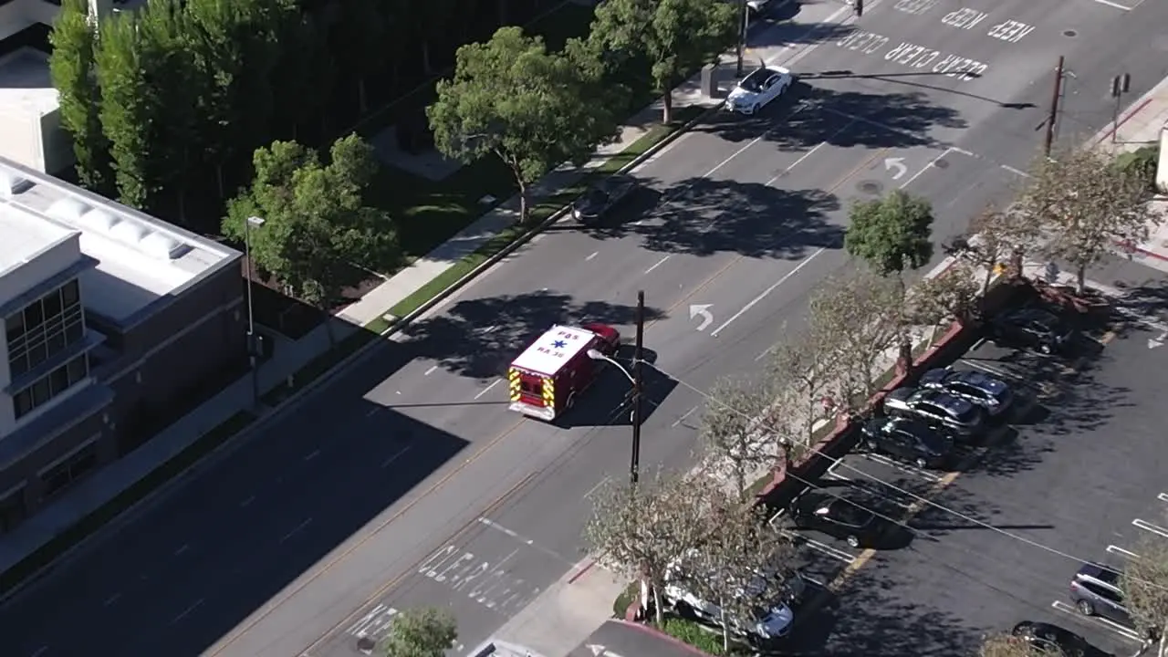 Aerial view tracking paramedic truck driving through city streets fast emergency response