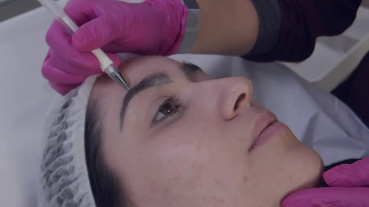 Close up cosmetic surgeon marking lines on botox patient's face