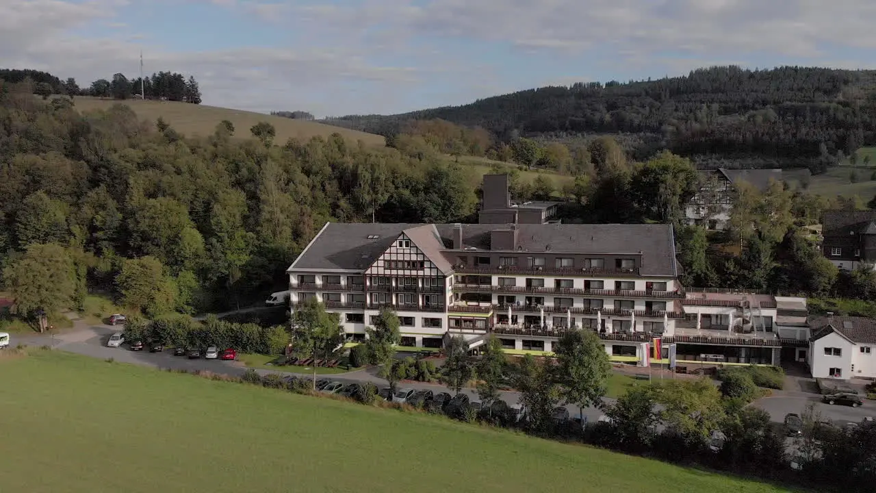 Aerial view of the Alpin hotel in the spa and ski village of Grafschaft in the Sauerland region near Winterberg against a blue sky with clouds