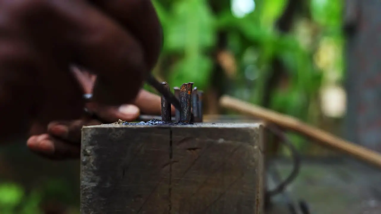 carpenter using old fashioned tools bend metal iron in construction site close up of skilled hands