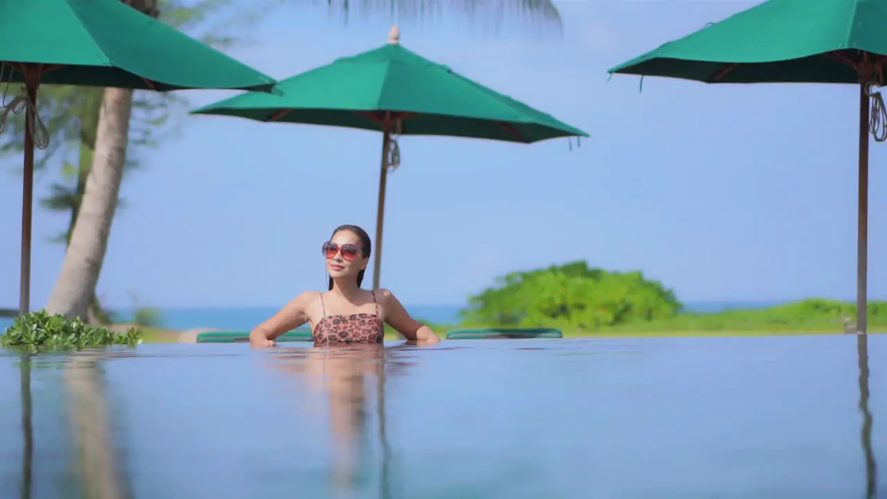 Sexy asian woman in swimming pool on a tropical destination water surface view full frame