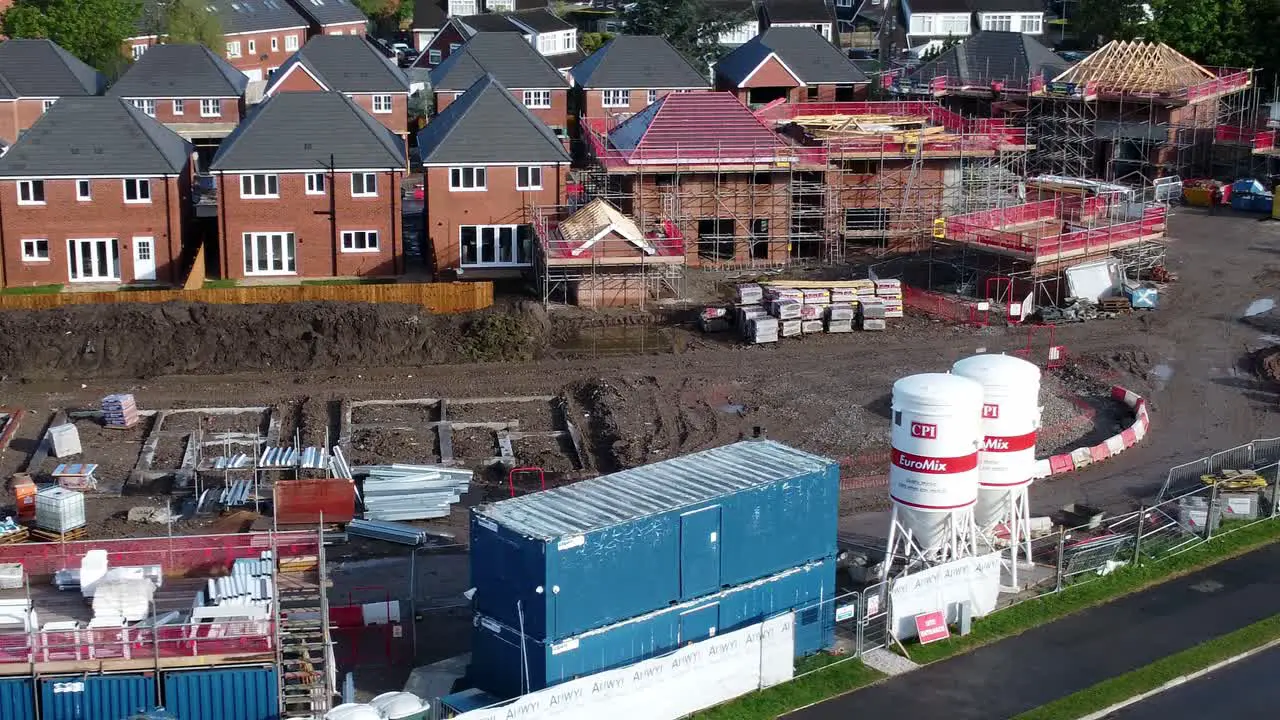 Construction site aerial view above new urban real estate housing development regeneration orbit close left shot