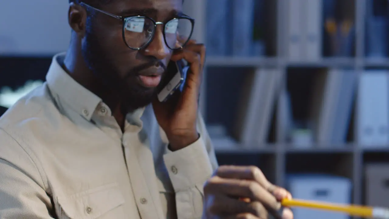 Close Up View Of Office Worker Speaking On The Phone About Work Project And Explaining Something On The Computer Screen With A Pencil In A Hand