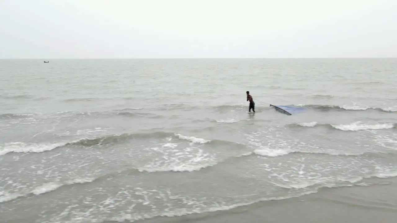 Fisherman Walking In The Sea Pulling Fishing Net In Kuakata Bangladesh