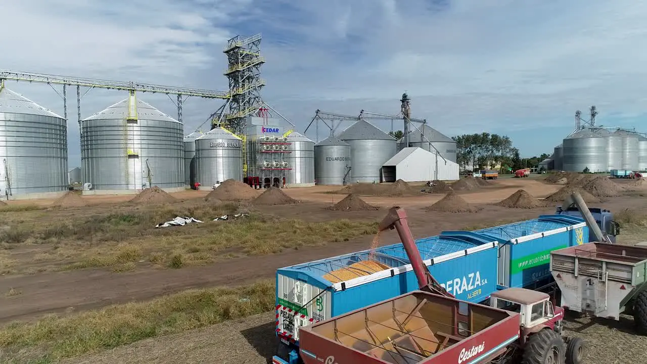 Grain being poured into a truck at a silo complex during a sunny day agricultural industry scene