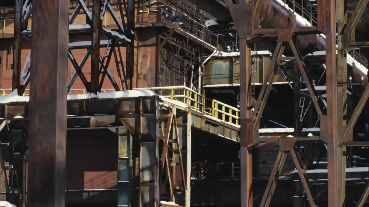 Abandoned rusting complex industrial building with metal pipes platforms rusted steel beams and supports