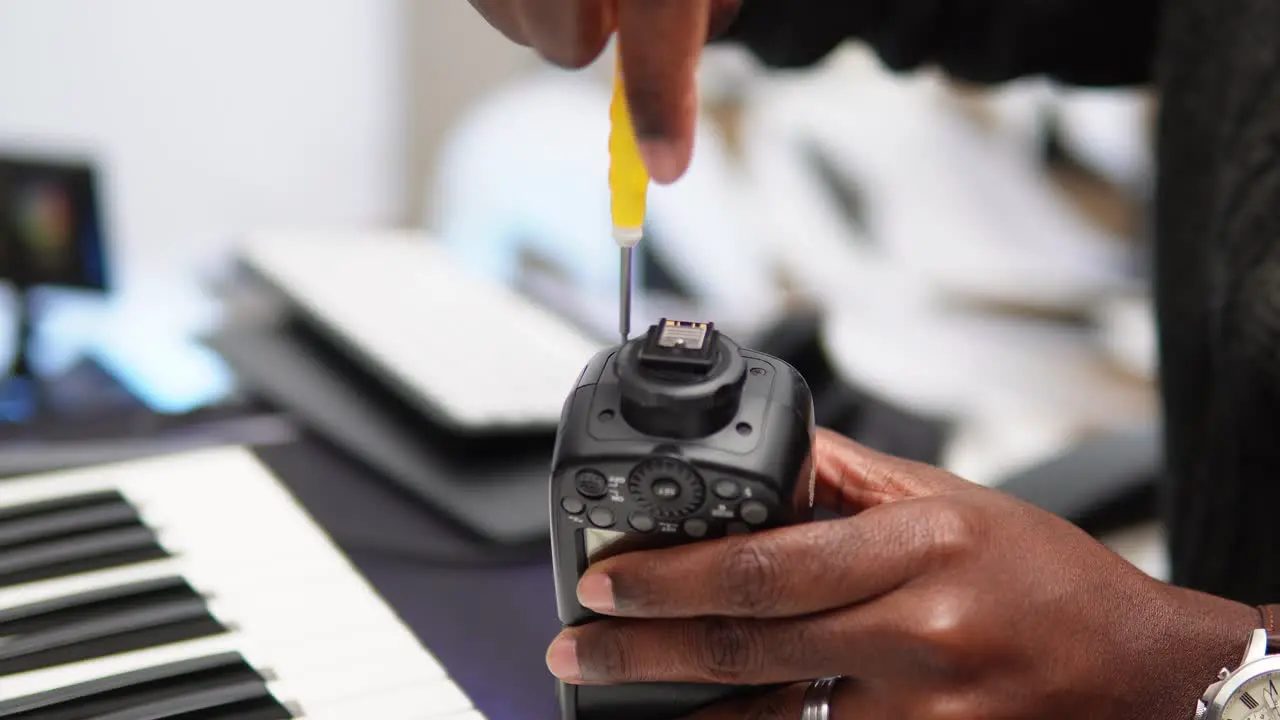 Man closing the camera flash with a screwdriver