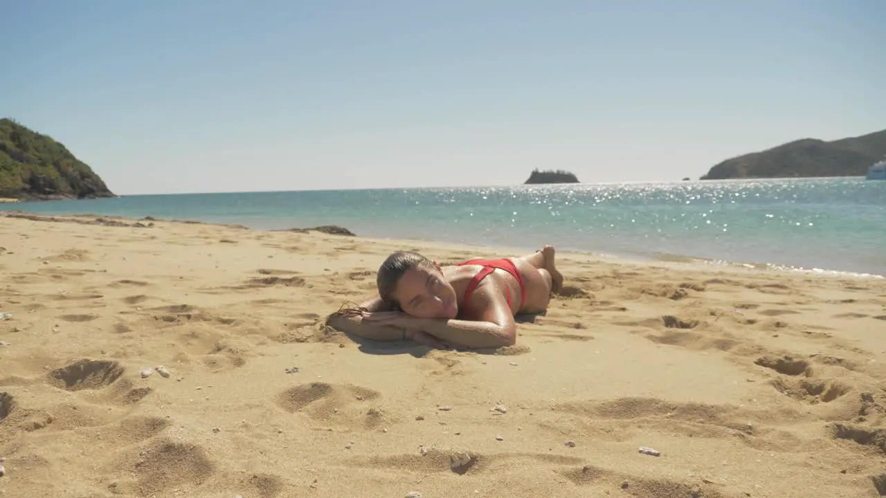 Female Tourist Relaxing And Sunbathing On Sandy Beach In Langford Island Whitsundays Queensland In Summer