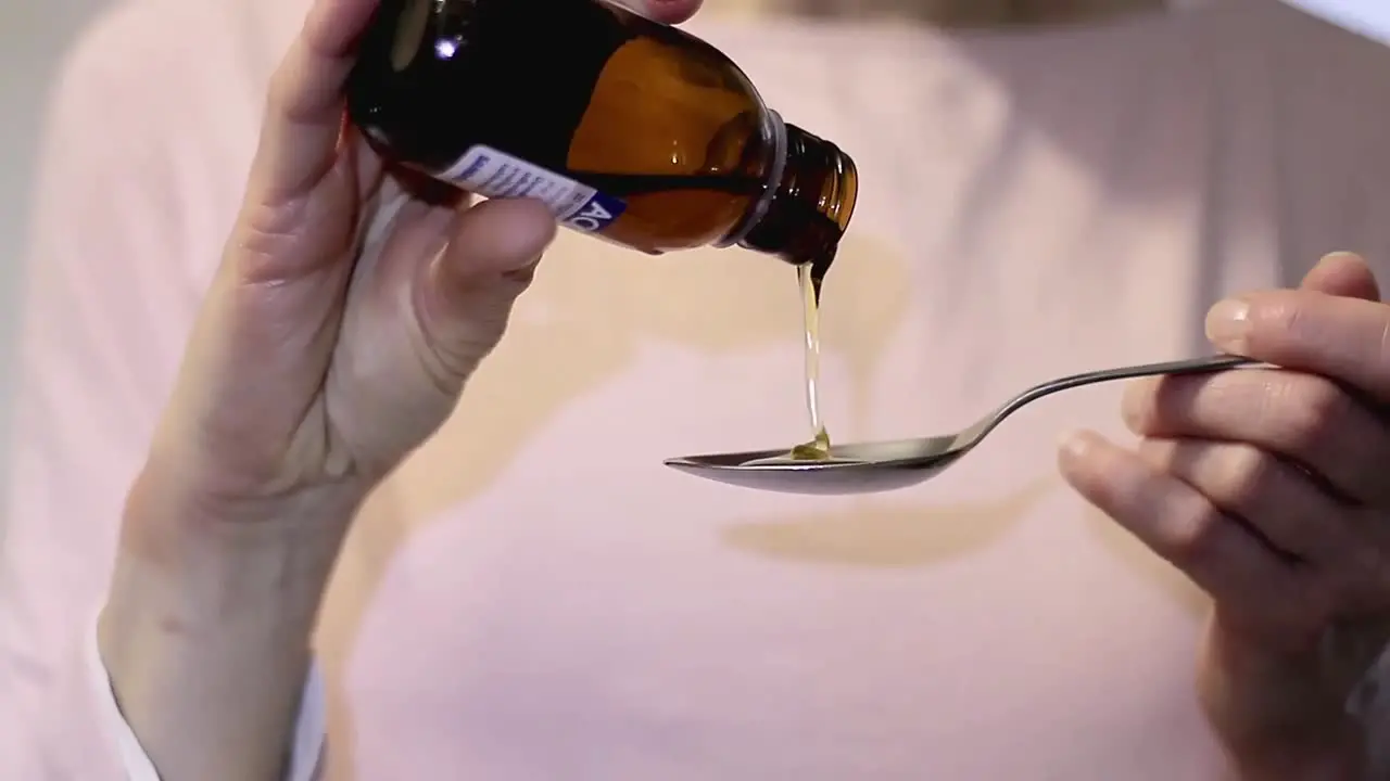 Healthcare pouring cough medicine in a teaspoon stock video stock footage