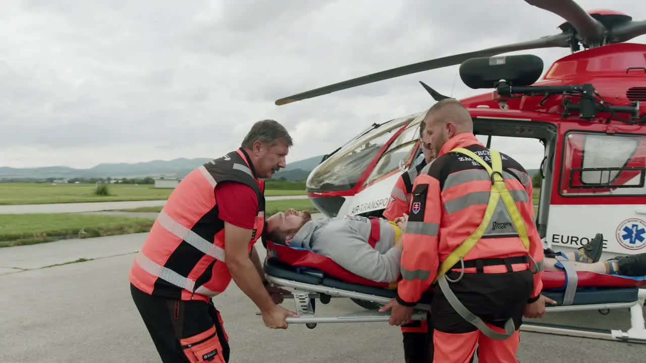 Medical crew taking patient from Red cross Helicopter slowmotion