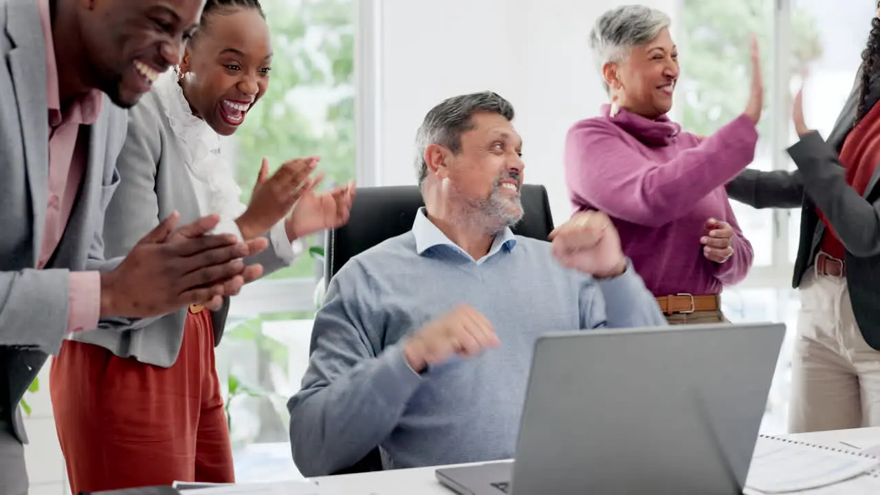 Man in office with laptop applause