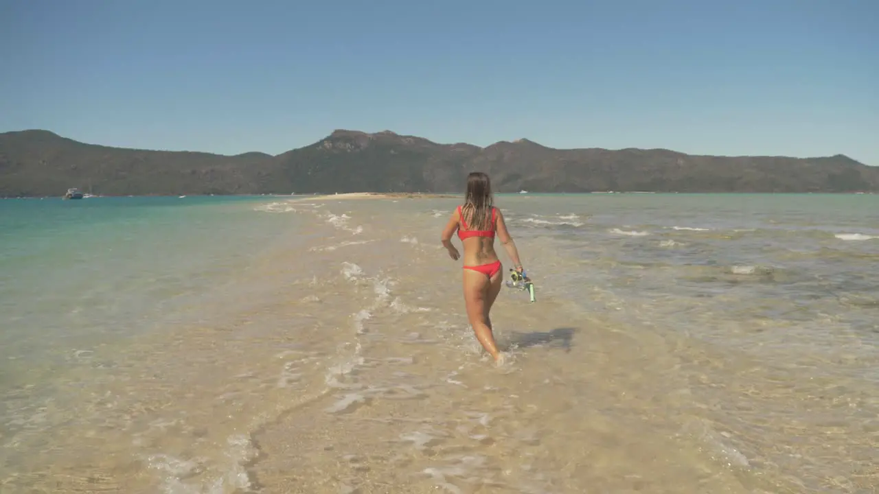 Woman in bikini walking through the beach waves -Langford Island Australia -Wide