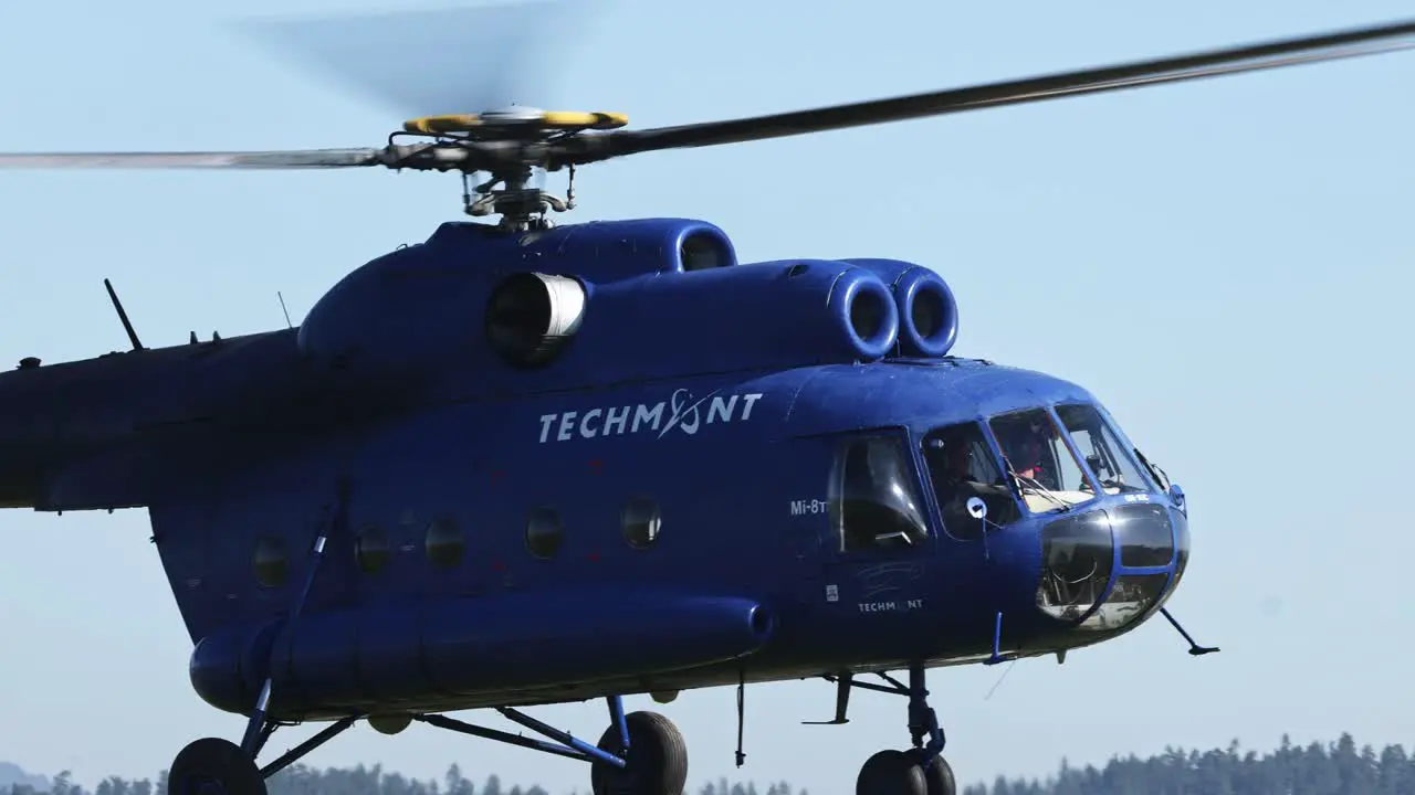 Civilian version of soviet era Mi 8 helicopter landing on airfield