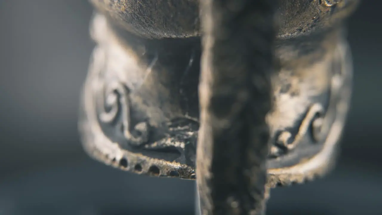 A close up macro detailed shot from behind of a spartan face design warrior ancient greek bronze helmet on a 360 rotating stand studio lighting 4K smooth movement