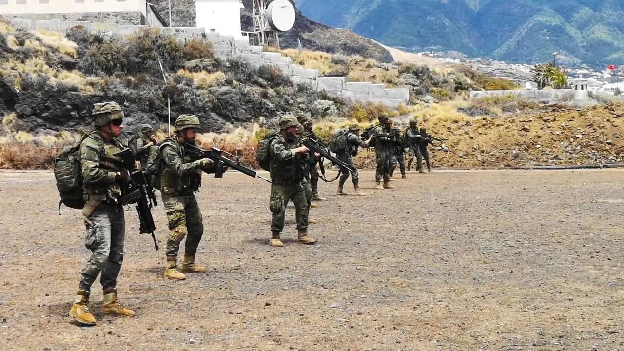 Army company walking in a shooting range a firing at the same time