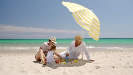 Grandma Mom and Little Girl Playing at Beach Sand