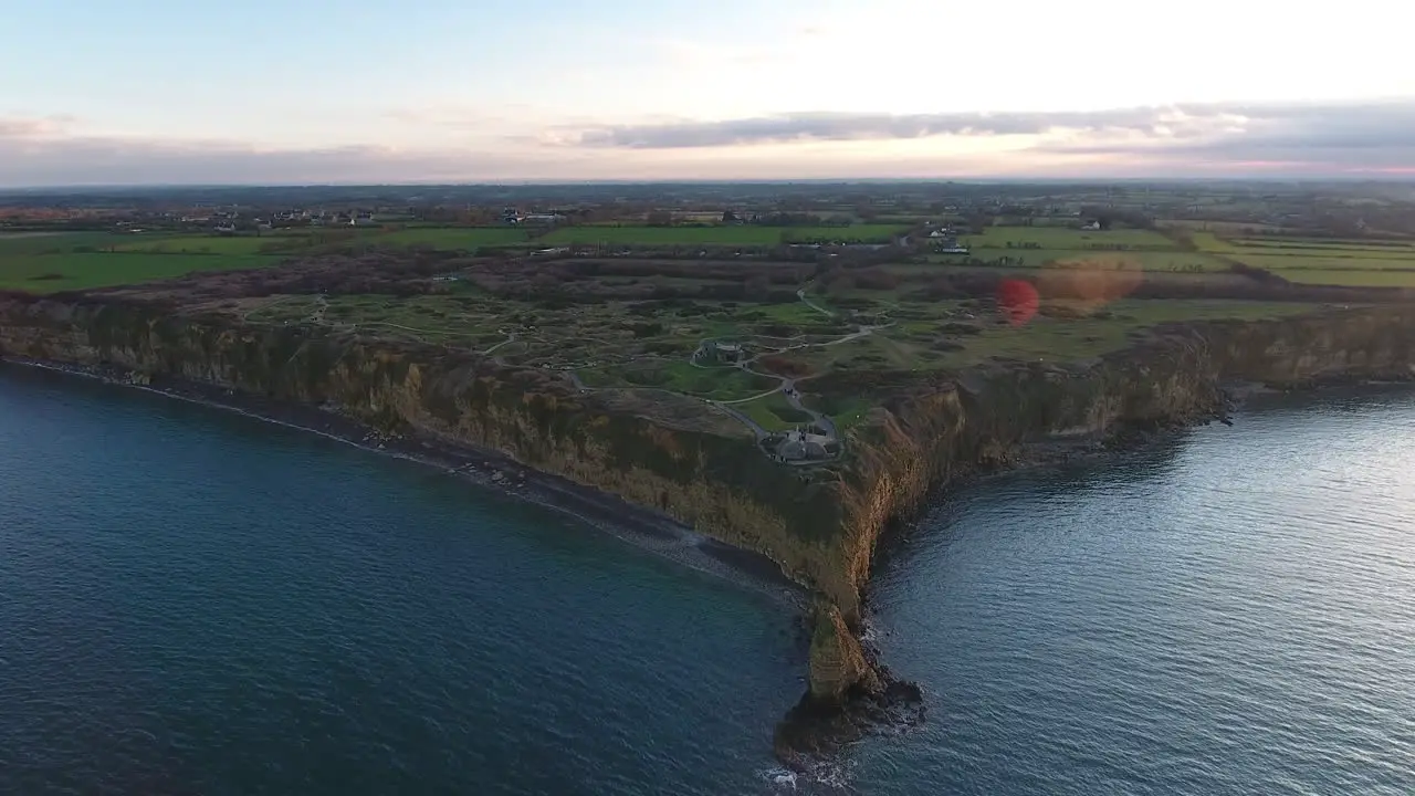 Aerial shot flying around Pointe du Hoc cliff overlooking English Channel WW2