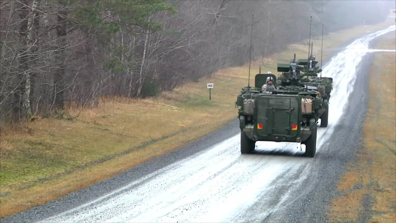 Armored Personnel Carrier Vehicles Roll Along A Small Road