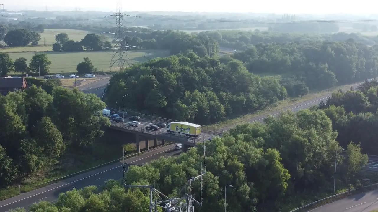 British countryside with vehicles travelling on highway background aerial descending view to 5G broadcasting tower antenna