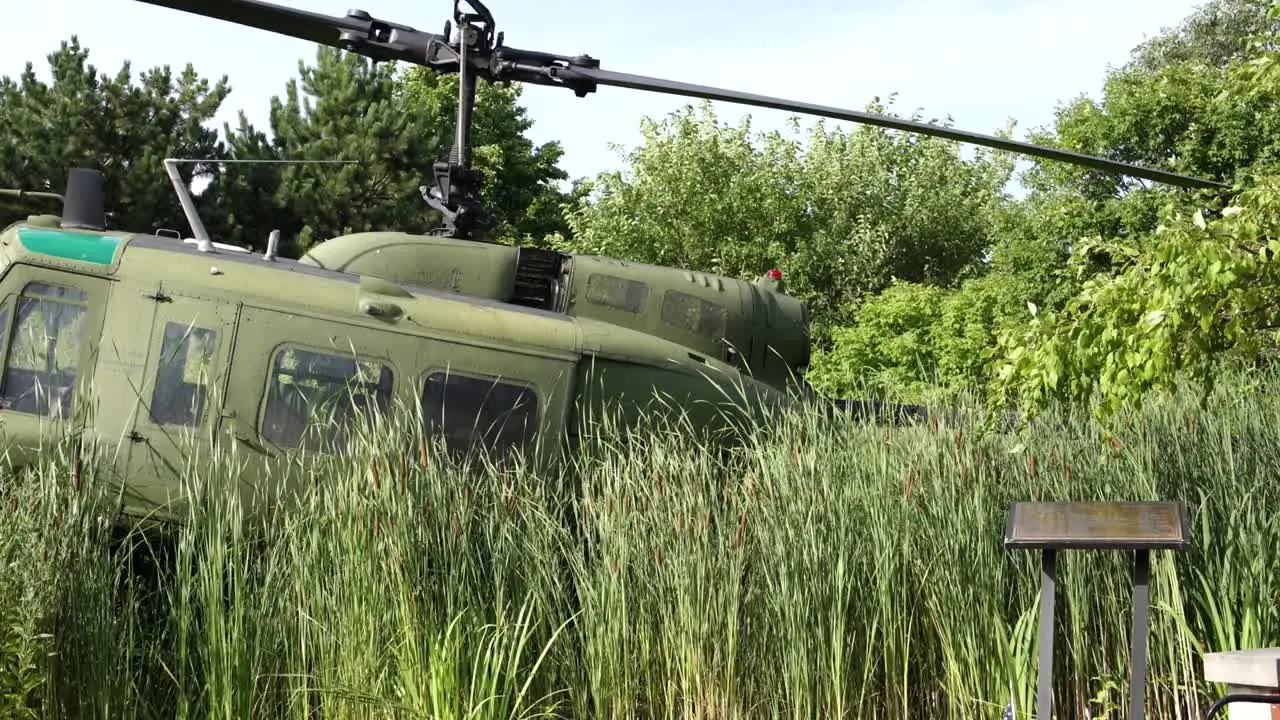 Community Veterans Memorial Army helicopter behind tall grass side view