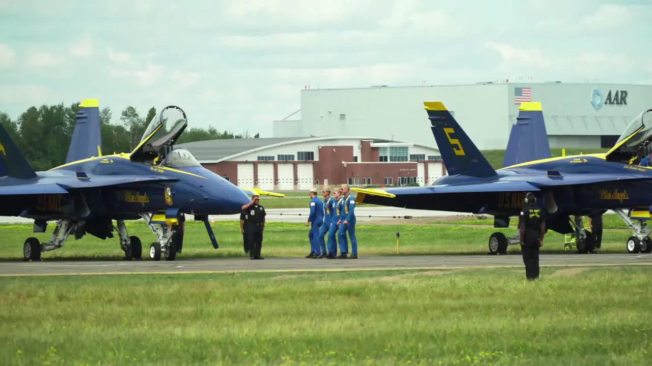 Blue Angels pilots marching in formation as they approach and enter their Boeing F-18 Hornet aircraft