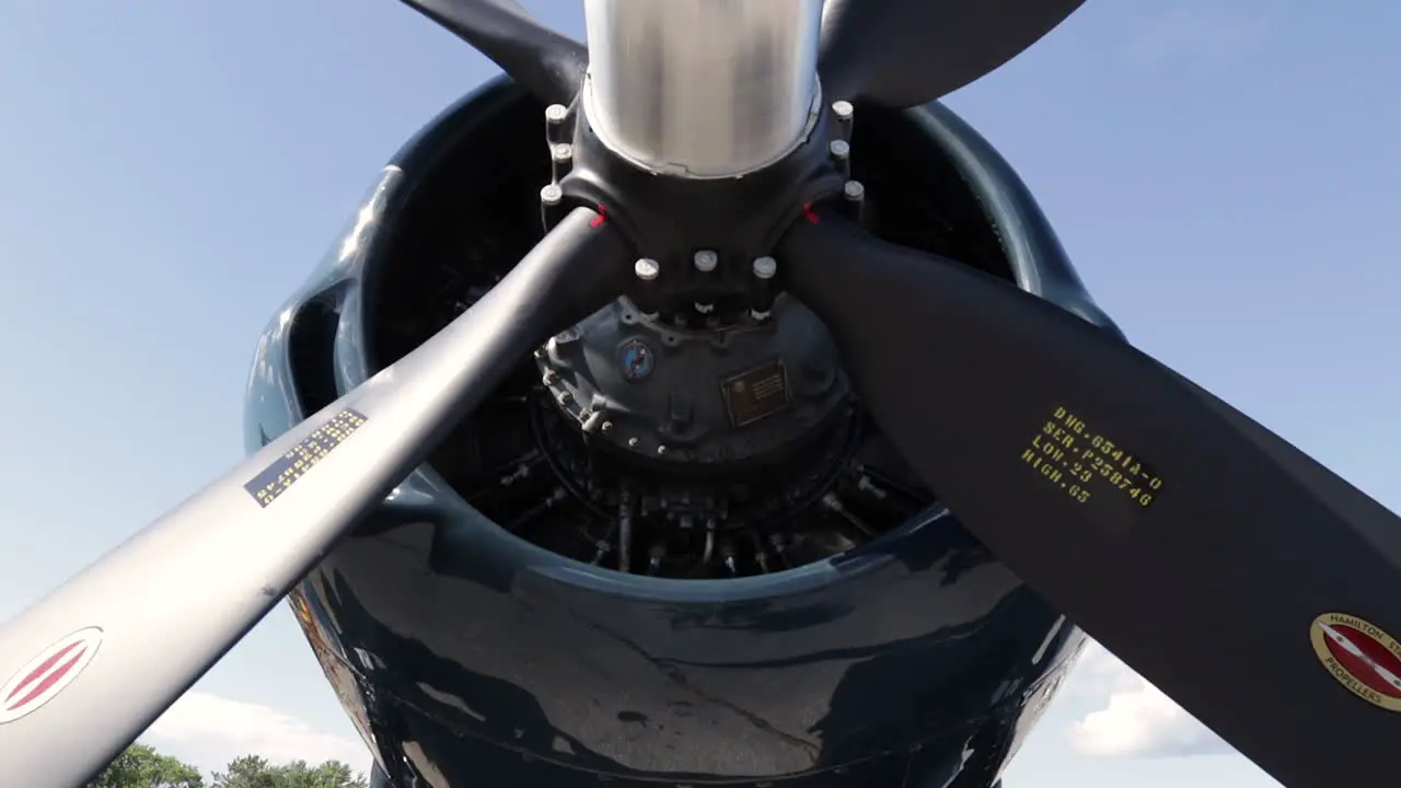 Panning shot of the front of an antique airplane parked at an air show for viewing