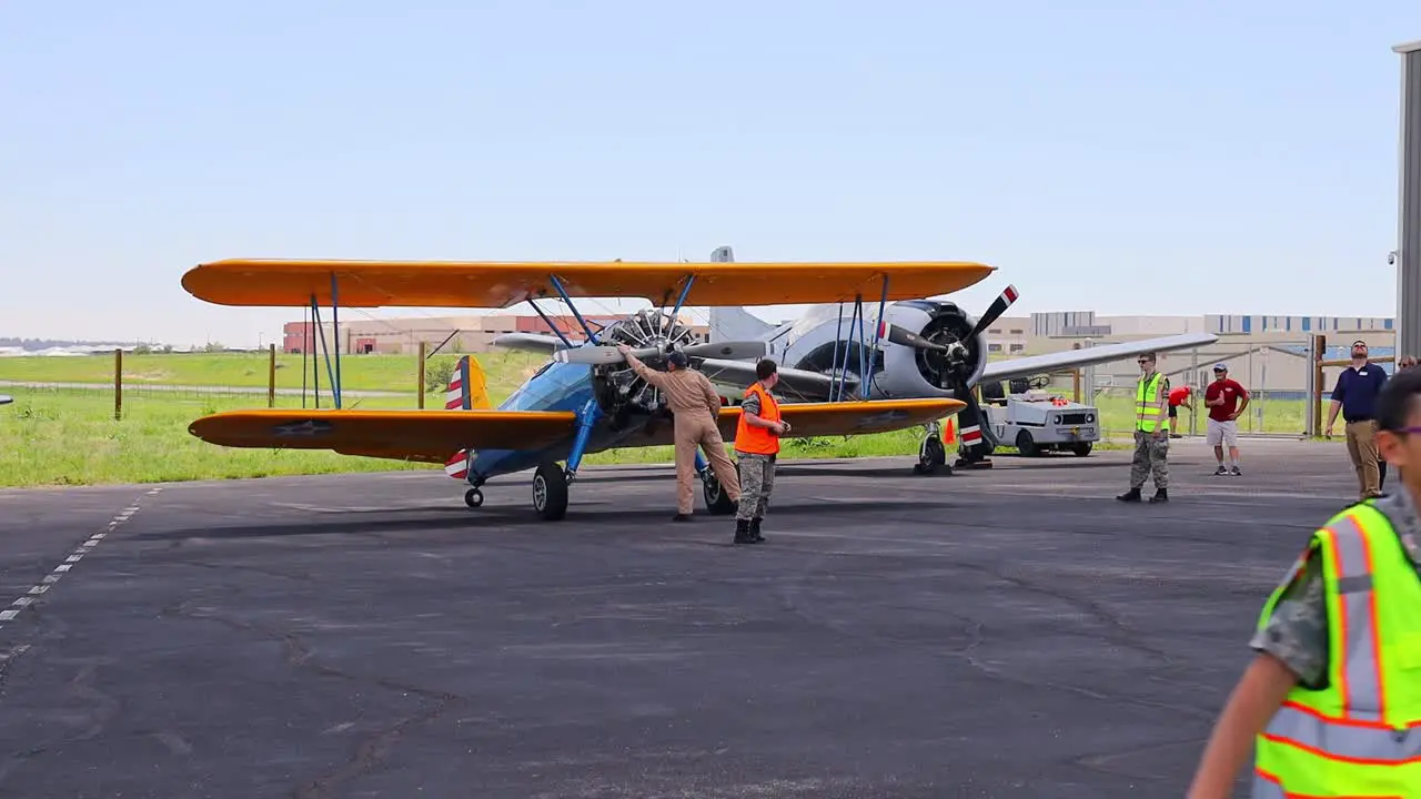 Pilot of a Boeing Stearman 75 vintage world war II training aircraft rotating the prop before starting the engine at an airshow at the Centennial Airport in Colorado