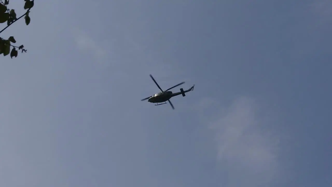 Slow motion of helicopter hovering in the air against a blue sky background