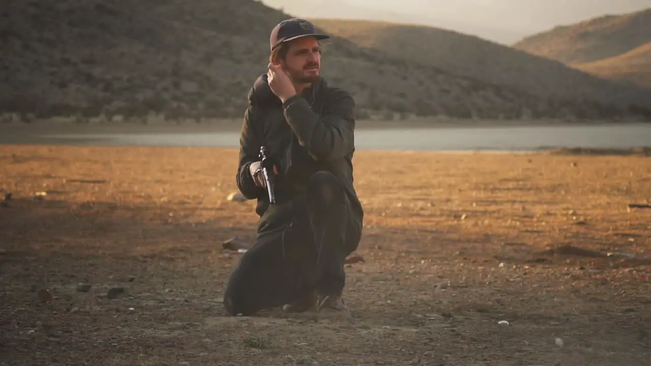 Proud shooter firing a rifle and adjusting ear clips at Lucerne Valley