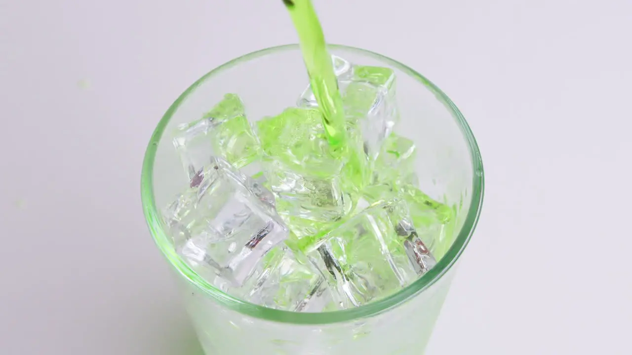 Pouring soft Drinks and green soda into Glass Isolated o White Background