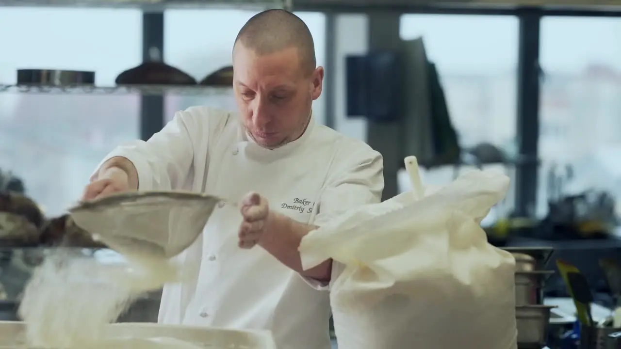 The baker sifts rye flour on bread